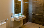 Bathroom with walk in shower and backlit mirror