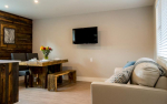 Living room with couch and table and TV mounted on wall