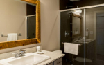 Bathroom with vanity, rustic mirror and glass shower