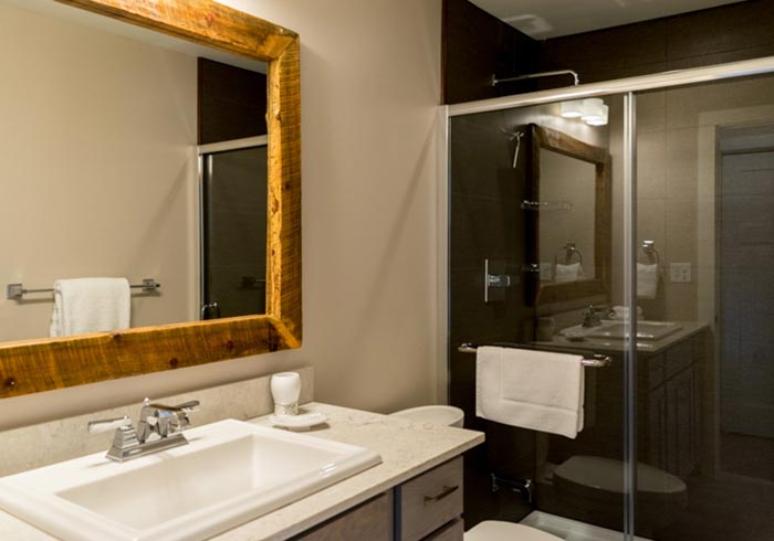 Bathroom with vanity, rustic mirror and glass shower